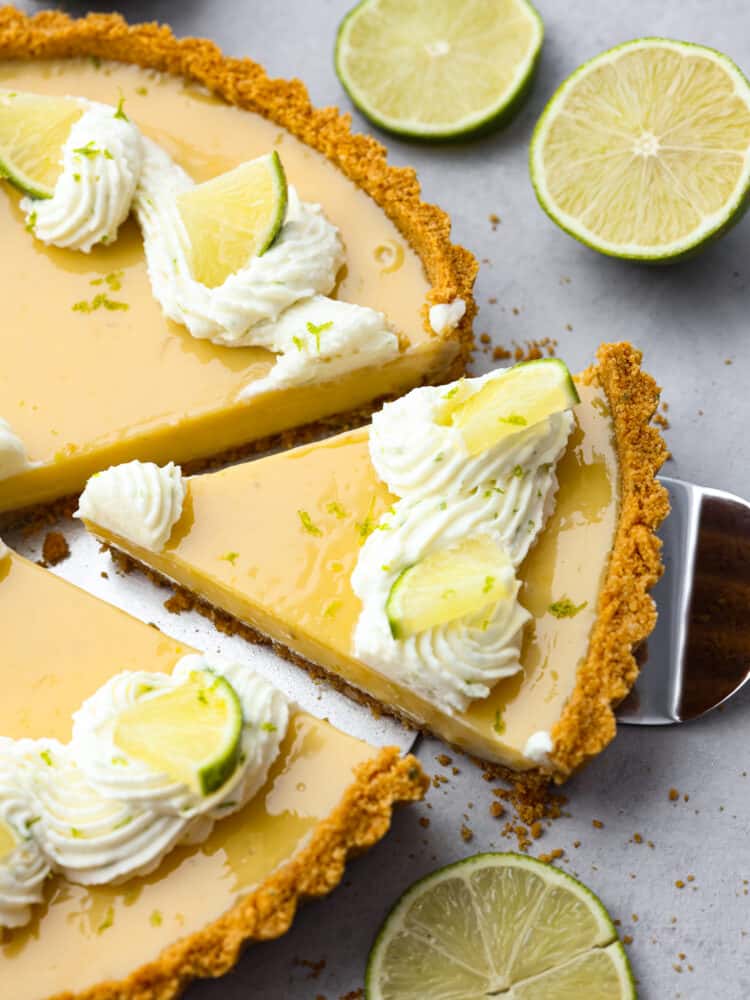 This traditional key lime tart with a graham cracker crust is a must-make dessert for the summer! Each bite is creamy, juicy, and the perfect balance of tart and sweet! Closeup of a slice of key lime tart.