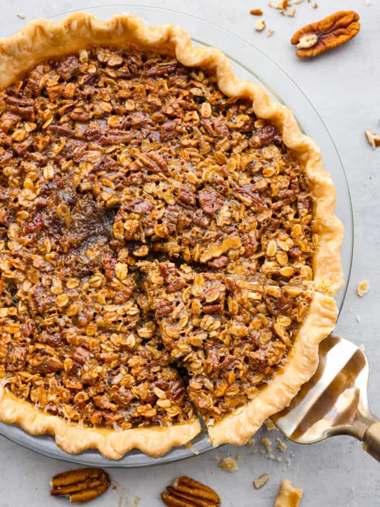 If you love pies, then this delicious and unique oatmeal pecan pie is for you! And if you haven't made a pie before, do not fear... this recipe really is so easy! The top view of an oatmeal pecan pie. A slice is cut out and about to be served with a silver pie server.