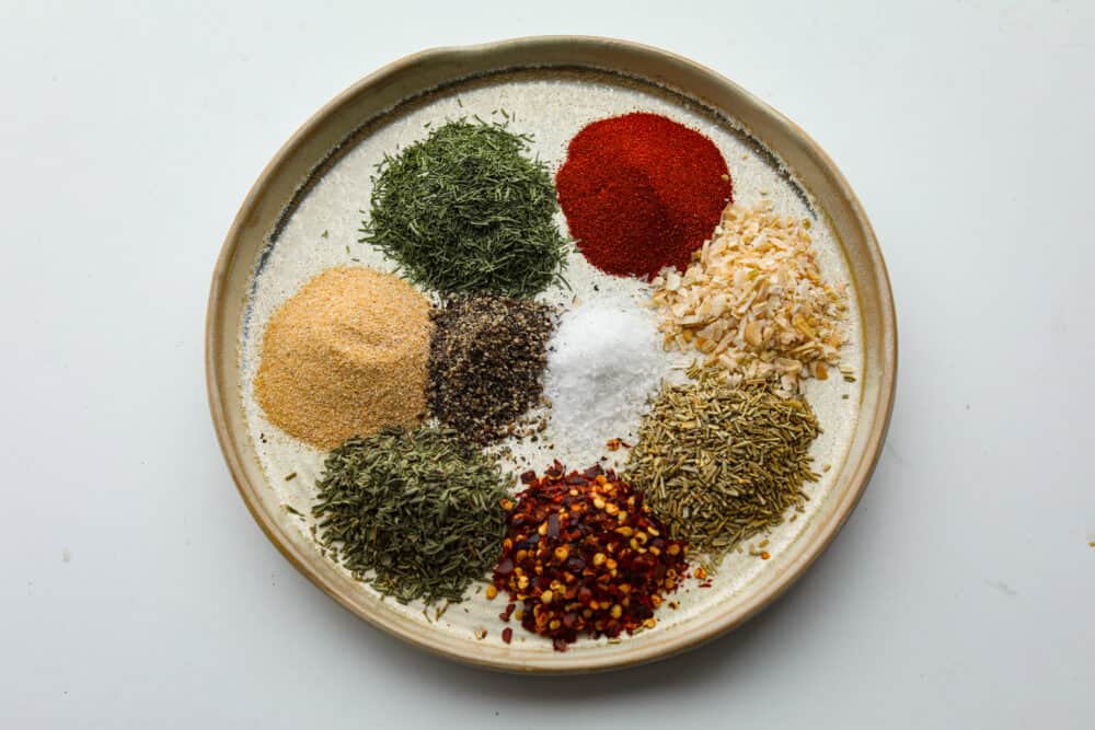 Get ready to add the most delicious flavor to your meat with this amazing steak seasoning! It packs a punch of flavor with garlic, onion, and herbs and will elevate any steak you cook! A bowl filled with seasonings and herbs measured out and ready to mix.