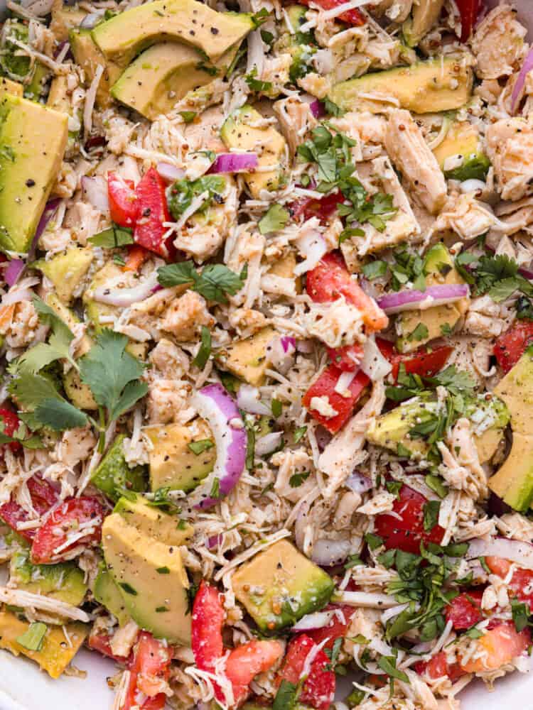 This fresh and flavorful avocado tuna salad is the perfect side dish for summer! The combo of bright veggies, savory tuna, and creamy avocado is one you don't want to miss! Closeup shot of avocado tuna salad.