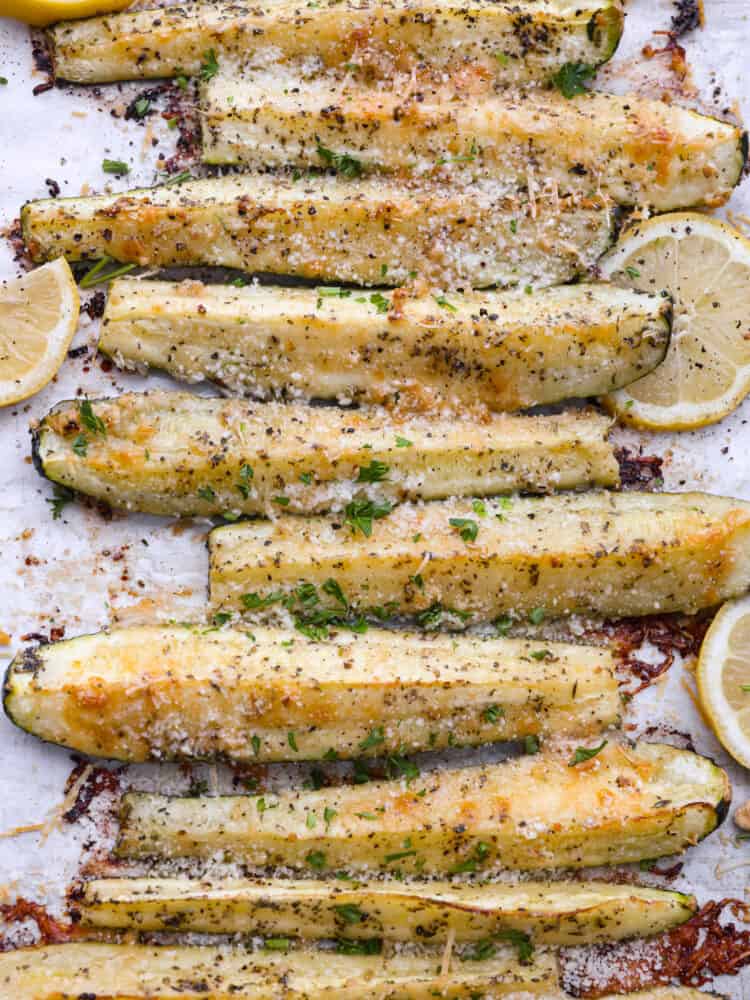 If you're looking for the best way to use up all that summer zucchini, this is it! Quick and easy zucchini spears coated in parmesan and garlic and roasted in the oven to perfection. Closeup of roasted zucchini spears seasoned with garlic and parmesan.