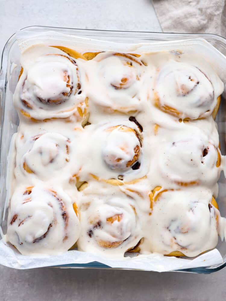 Quick 45 Minute Cinnamon Rolls are made with homemade dough filled with groundย cinnamon, and a brown sugarย mixture rolled and baked in less than an hour. Drizzle a sweet glaze over the top, making this the VERY BEST breakfast! The top view of 45-minute cinnamon rolls, baked and in a pan with a glaze on top.