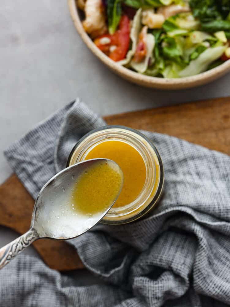 Apple cider vinaigrette is a staple dressing for adding a burst of bright, tangy flavor to your favorite salads. Make it from scratch and you won’t want it any other way! Top-down view of a spoonful of apple cider vinaigrette.