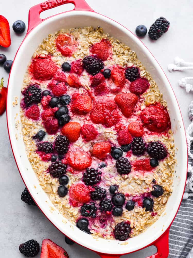This baked berry oatmeal is a TikTok sensation that's every breakfast lover's dream! Warm, milky, and loaded with fresh berries, it's the most delicious way to start your day. Top-down view of oatmeal in a baking dish, garnished with fresh berries.