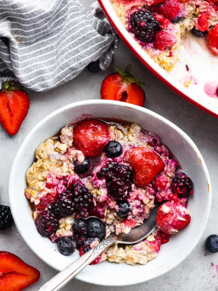 This baked berry oatmeal is a TikTok sensation that's every breakfast lover's dream! Warm, milky, and loaded with fresh berries, it's the most delicious way to start your day. Cooked oatmeal in a white bowl, garnished with berries and ready to eat.