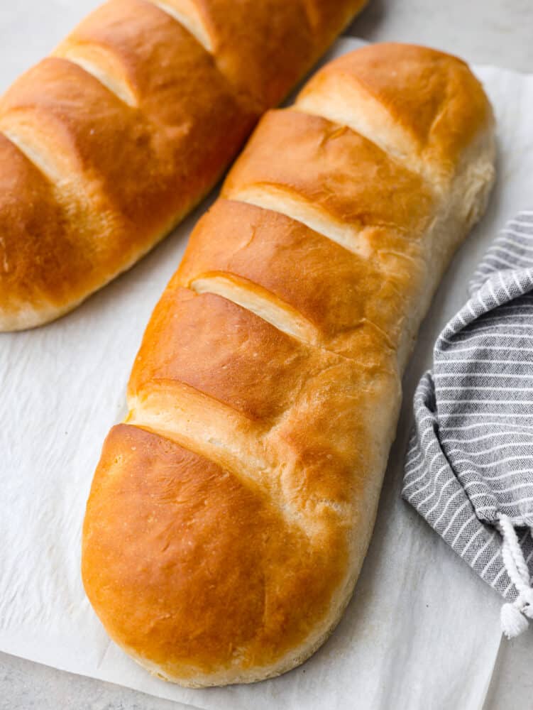 Making homemade French bread is a game-changer! Golden on the outside and supremely soft and tender on the inside, it will complement any meal perfectly! Closeup of a loaf of French bread.