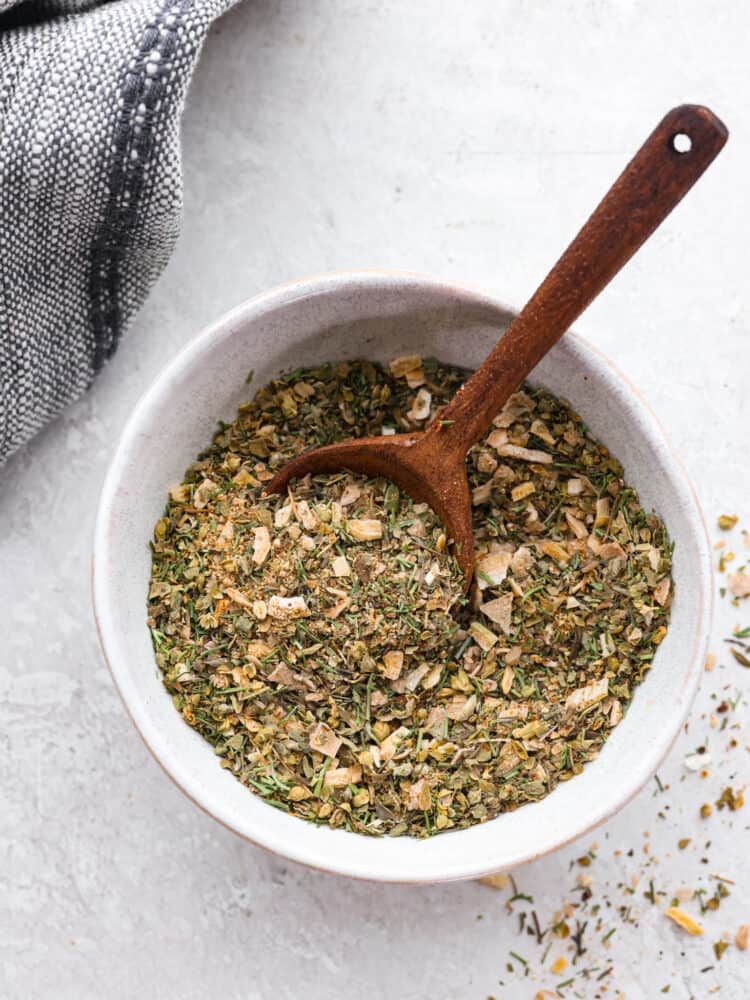 Using homemade Greek seasoning is the best way to add Mediterranean flair to your cooking! It mixes up in minutes and is perfect for adding delicious zesty flavor to all of your favorite meals. Top-down view of Greek seasoning in a white bowl.