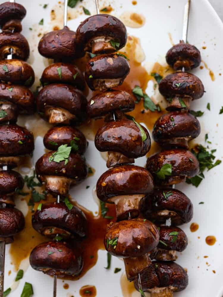 These vegan kabobs are the most delicious side dish that you MUST try! These grilled honey soy mushroom skewers are the perfect side dish for any entree, and you won't be able to stop at just one! A close-up of grilled honey soy mushroom skewers.