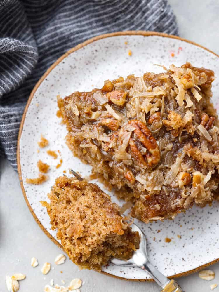 You have to make this oatmeal cake. Itโs an old-school recipe that doesnโt look like much, but that buttery pecan and coconut topping? Itโs gooey, crunchy, and totally addictive! Slice of oatmeal cake on a plate with a fork.