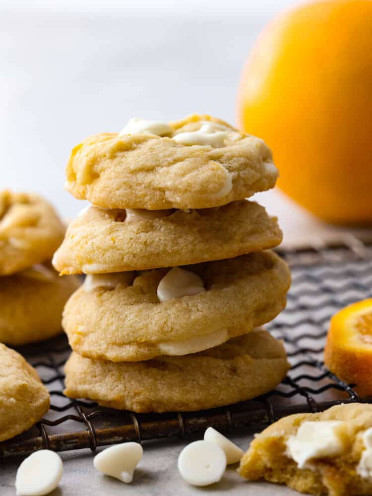 If you love orange creamsicles, you're going to LOVE these cookies! They're soft, buttery, and loaded with orange zest and white chocolate chips. A stack of 4 creamsicle cookies.