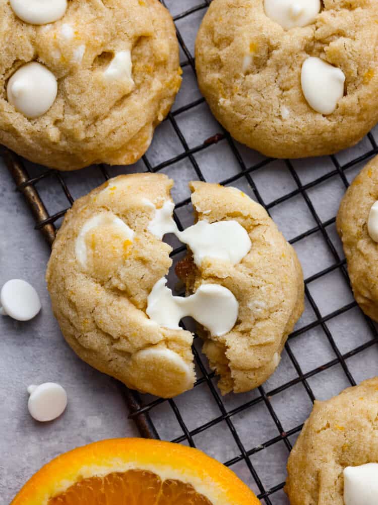 If you love orange creamsicles, you're going to LOVE these cookies! They're soft, buttery, and loaded with orange zest and white chocolate chips. Closeup of a creamsicle cookie torn in half.