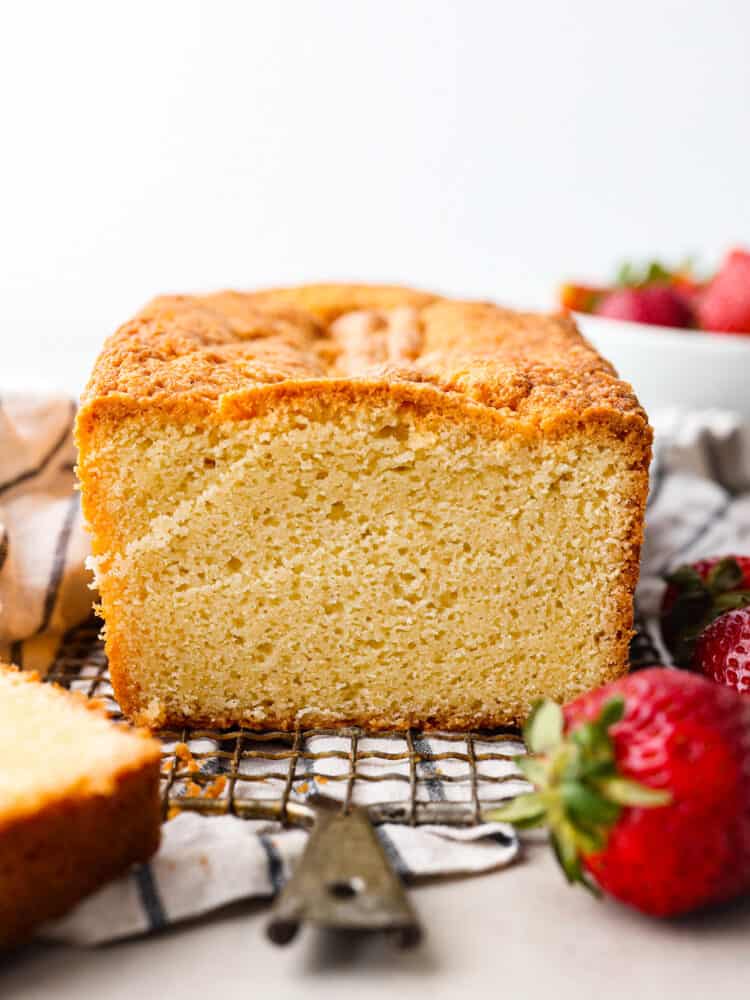 This is a classic recipe that really IS the perfect pound cake! There is something about this exact mix of these simple pantry staple ingredients that results in a velvety smooth and perfectly dense and tender cake. A loaf of pound cake sitting on a wire rack.