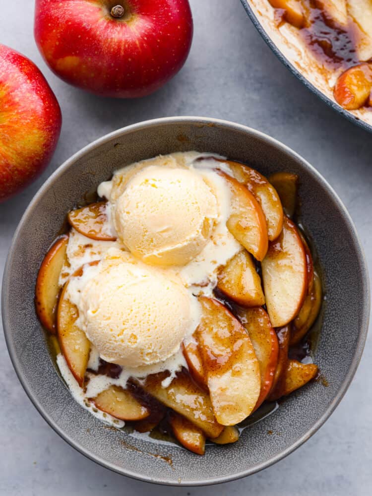 These apples are sautéed in a brown sugar and cinnamon mixture, making them insanely delicious! It's a match made in heaven when you top them with some vanilla ice cream or whipped cream! These apples are sautéed in a owl with vanilla ice cream on top.