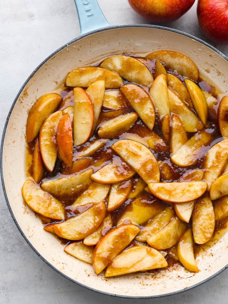 These apples are sautéed in a brown sugar and cinnamon mixture, making them insanely delicious! It's a match made in heaven when you top them with some vanilla ice cream or whipped cream! A pan filled with sauteed apples in a brown sugar, cinnamon sauce.