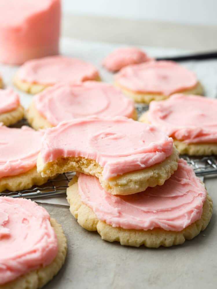 Look no more; this is the best copycat recipe out there for the famous Swig sugar cookie! These Swig sugar cookies are perfectly soft and topped with the most delightfully sweet frosting that you will ever try. You will definitely not be able to stop at just one! A stack of sugar cookies with a bite taken out of the top one.