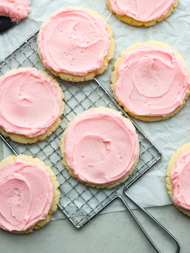 Look no more; this is the best copycat recipe out there for the famous Swig sugar cookie! These Swig sugar cookies are perfectly soft and topped with the most delightfully sweet frosting that you will ever try. You will definitely not be able to stop at just one! The top view of Swig sugar cookies on a cooling rack, ready to eat.