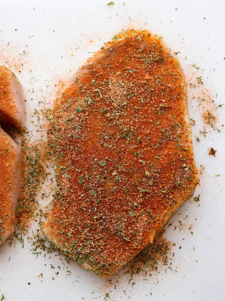 Enhance the flavor of any fish with this incredible all purpose fish seasoning. Delicious spices and herbs right from your pantry make the perfect blend to season any type of fish for grilling, baking, or pan searing. A close up photo of a fish fillet seasoned with the fish seasoning.