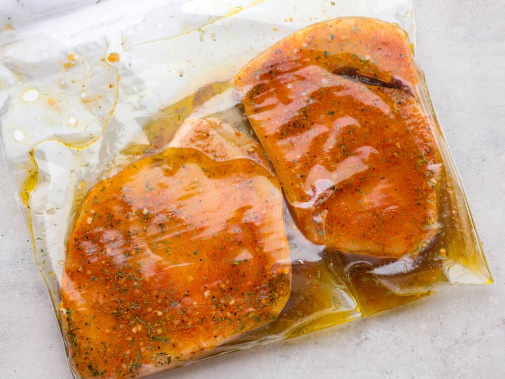 Delicious and seasoned swordfish simply grilled and seared to perfection! This tender grilled swordfish has a flavorful marinade of spices that give the fish maximum flavor. Marinating swordfish steaks in a ziplock bag.