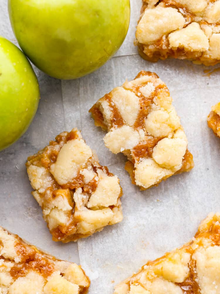 Salted caramel apple bars are ooey-gooey treats that have an amazing buttery shortbread crust and a soft and sweet caramel apple center!ย This is one of the best desserts you will make this fall! The topview of a caramel apple bar broken in half