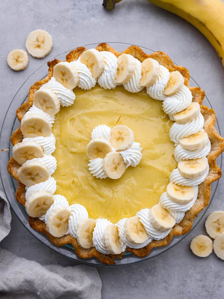 A classic dessert, made with a creamy vanilla bean and banana custard filling! This banana cream pie recipe is foolproof and ready to please a crowd! Top-down view of a whole banana cream pie.