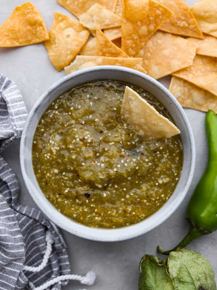 Fresh and delicious tomatillo salsa is the key to any successful Mexican meal! This is packed with so much flavor, and you will want to use it on everything! Top-down view of tomatillo salsa served in a white bowl.