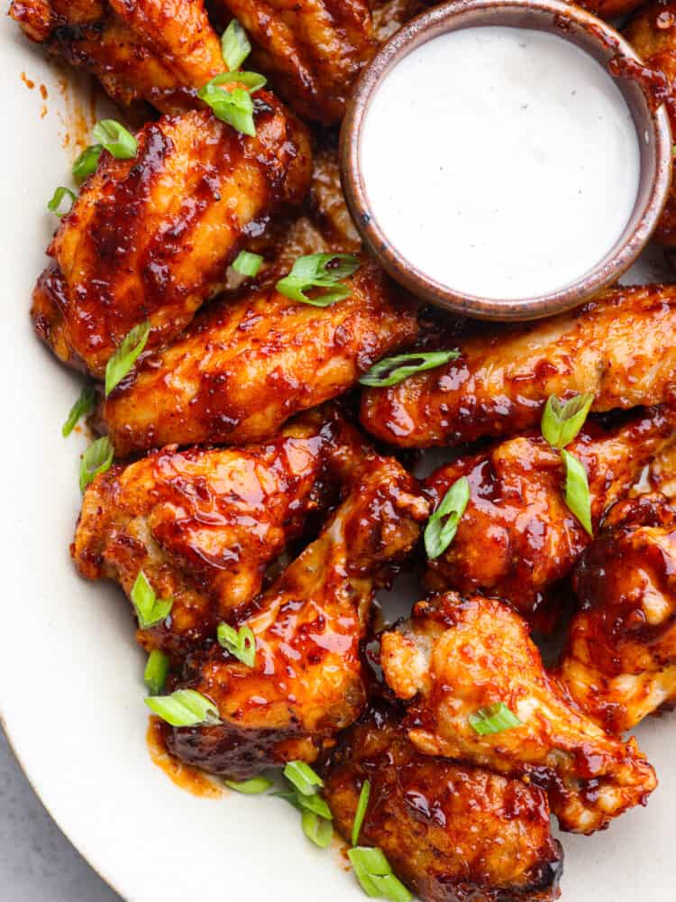 Honey chipotle wings are sweet and spicy and pack a punch of flavor! You will definitely want to serve them as an appetizer on any game day, and they will be the hit of the party! A platter of honey chipotle wings with some ranch dipping sauce.