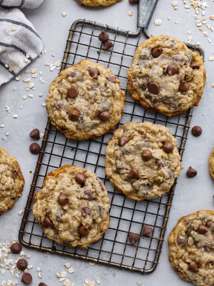 These oatmeal chocolate chip cookies are crispy on the outside, chewy on the inside, and loaded with chocolate! They are insanely delicious, and the flavors combine to make the best cookie of all time! Oatmeal chocolate chip cookies on a cooling rack.