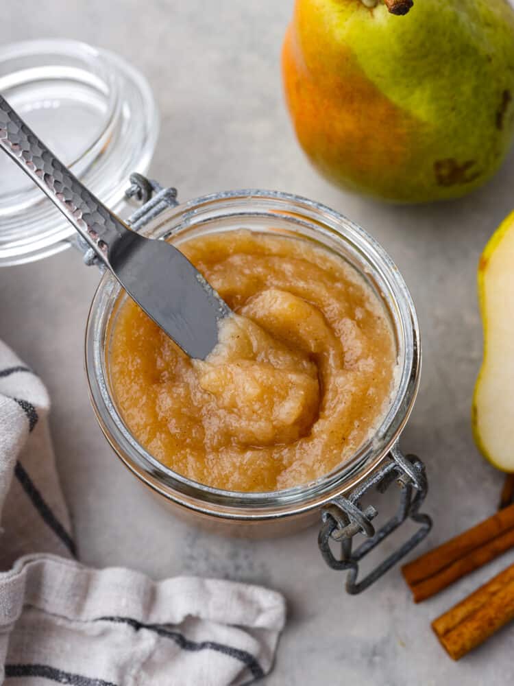 Sweetened with honey and warm spice, this homemade pear butter is a fall staple you'll want to put on everything! It's great for canning and storing to enjoy with all of your favorite baked goods year-round. Top-down view of pear butter in a glass jar.