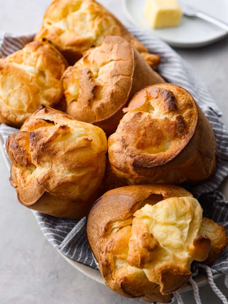 Golden, crisp, and deliciously airy, these homemade popovers are the best addition to any meal! Made with a simple egg batter, popovers have a buttery texture and the perfect chew! 6 popovers in a serving dish.