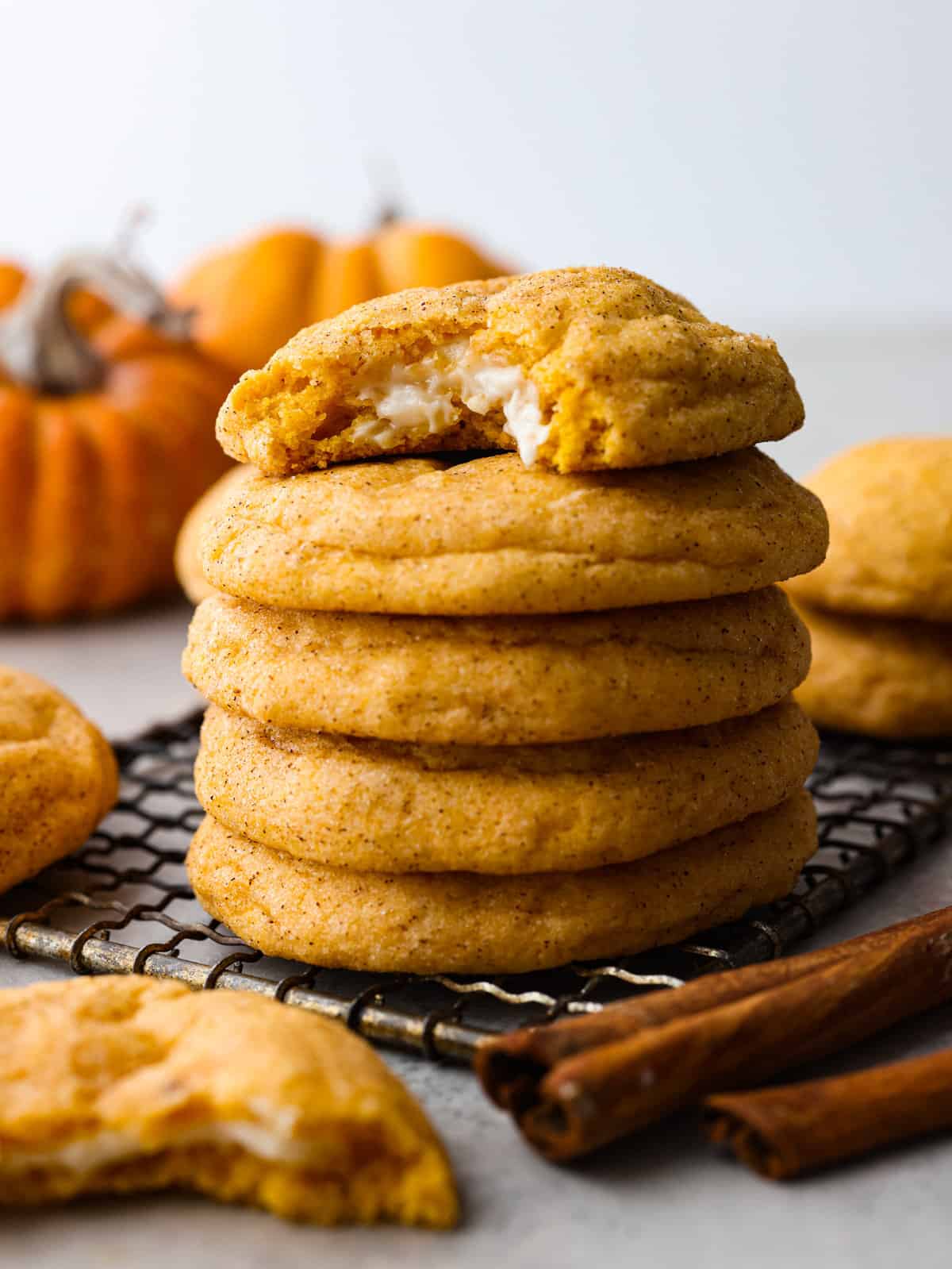 Pumpkin cheesecake snickerdoodles are a fresh take on a classic cookie! Delightfully soft and filled with tangy cream cheese, these cookies will be sure to get a "WOW!" from your friends and family! A stack of cookies.