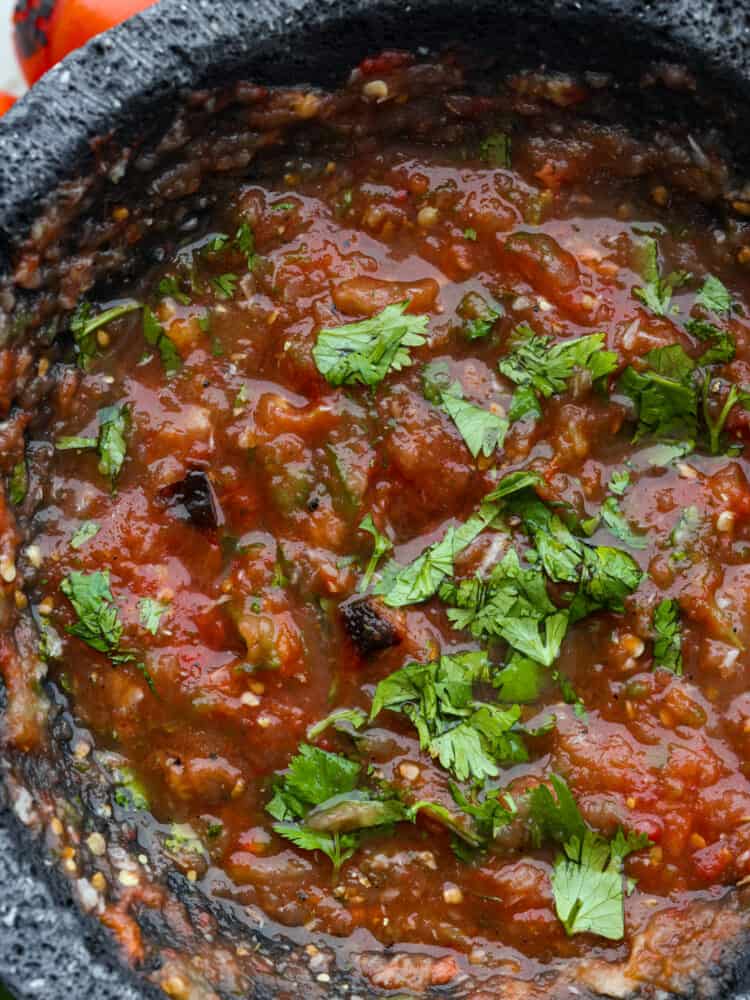 Prepare for the best salsa of your life! This roasted tomato salsa is the best combination of smoky, sweet, and spicy! Youโll be hooked after one dip. Closeup of salsa tatemada.