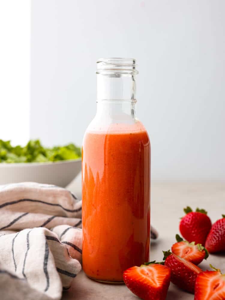 This strawberry vinaigrette is a delicious combination of sweet and tart all at the same time. It's the perfect way to brighten up any meal and it's so flavorful that you'll find yourself putting it on everything! A glass bottle of strawberry vinaigrette.
