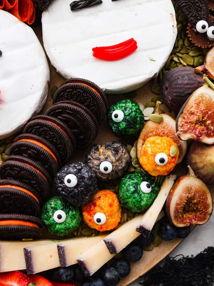 A tribute to the Sanderson Sisters, this Hocus Pocus charcuterie board will have all of your guests dying at not only the delicious variety of food but the uncanny resemblance to some of Halloween's most famous witches! A close up picture of the Rice Krispie Eyeballs on a Hocus Pocus Charcuterie Board.