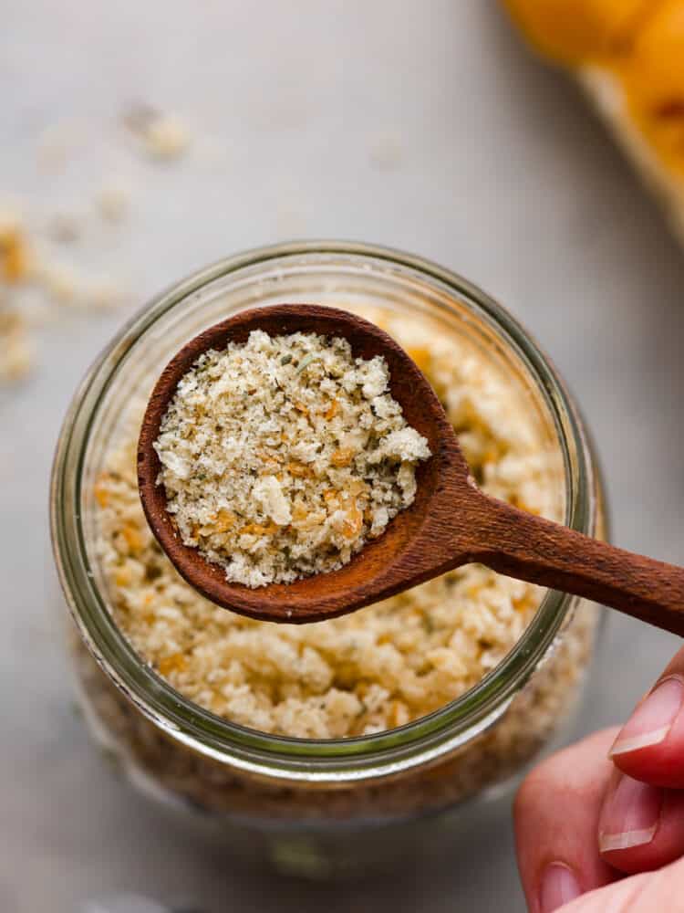 Having homemade breadcrumbs on hand is a great way to add extra flavor and texture to your meals. They're free of preservatives and are seasoned with delicious Italian herbs to level up all of your favorite recipes! Closeup of homemade breadcrumbs in a wooden spoon.