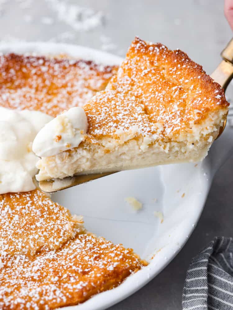 Don't be fooled by the name, this impossible pie is one of the easiest pies you'll ever make! Called "impossible" because it magically forms its own crust, you can have this pie ready for the oven in just 7 minutes. This pie is a classic for a reason- the creamy custard filling and crunchy topping are irresistible! A slice of impossible pie being picked up with a metal cake spatula.