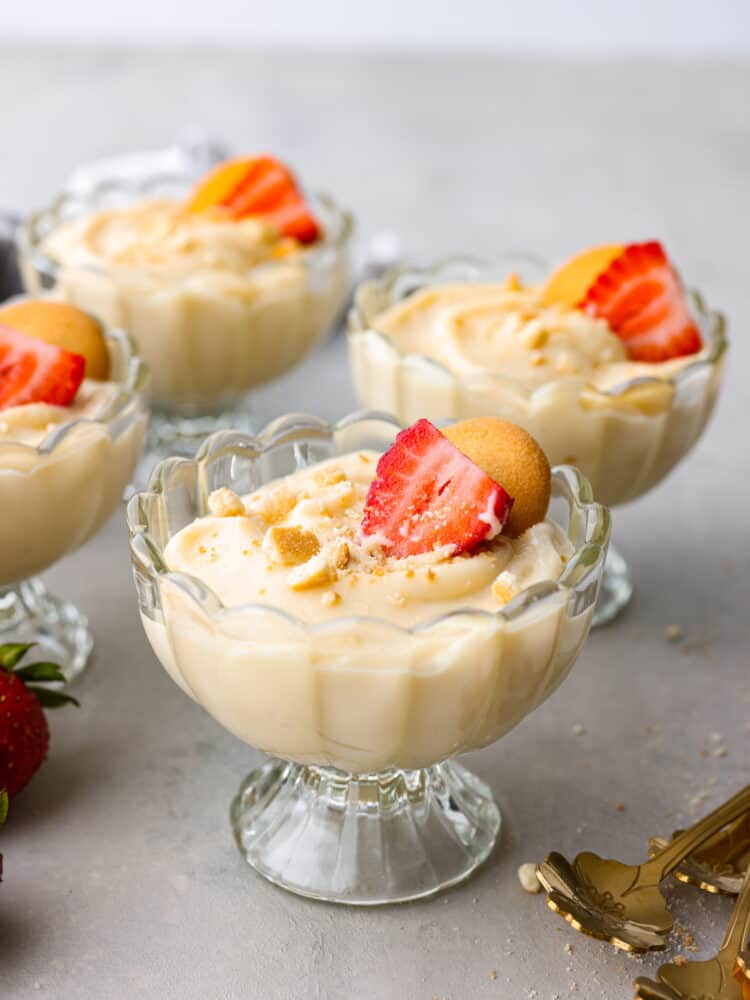 If you're looking for a tried and true vanilla pudding recipe, this is it! This homemade vanilla pudding is perfectly sweet, silky smooth, and really easy to make! Vanilla pudding served in small glass cups garnished with sliced strawberries and cookies.