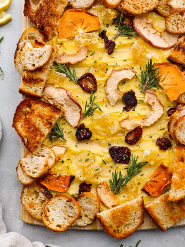 A butter board is the latest trend that you absolutely MUST TRY for your next gathering! This board is packed with the most delicious butter that is drizzled with honey and lemon zest and adds the perfect touch to your favorite bread! A closeup of a finished butter board.