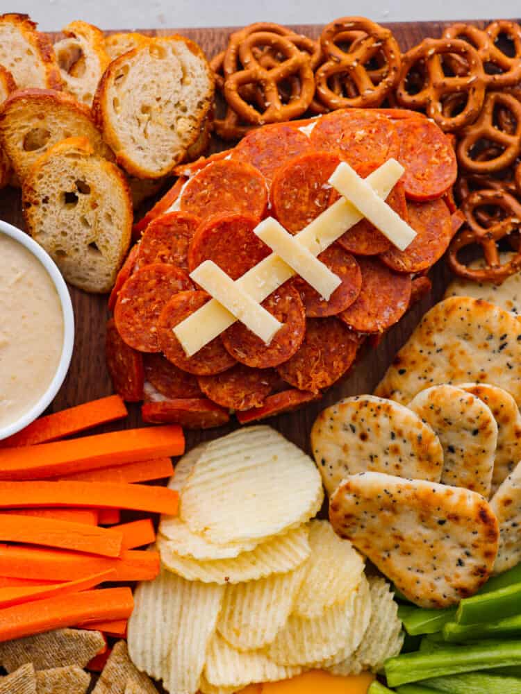 This football charcuterie board is perfect for any of your game day or tailgate parties! It's packed with all of the perfect finger food that everyone will love and you will be making this over and over during football season! A closeup of the football shaped cheeseball.
