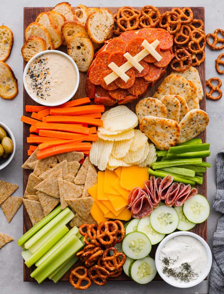 This football charcuterie board is perfect for any of your game day or tailgate parties! It's packed with all of the perfect finger food that everyone will love and you will be making this over and over during football season! The top view of a football charcuterie board.
