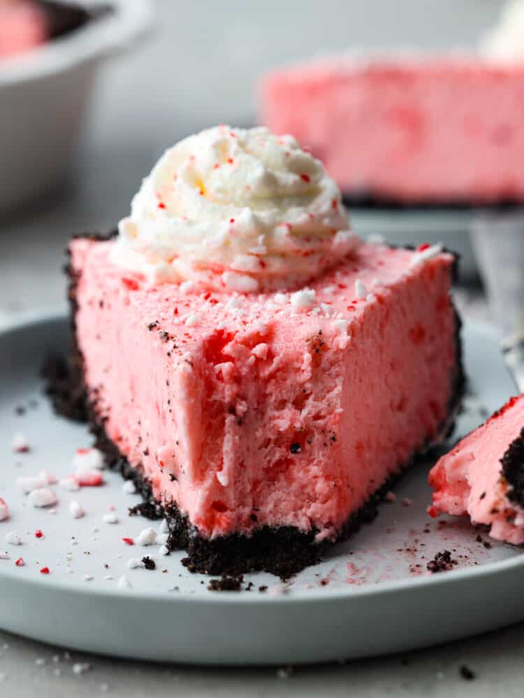 If you are looking for the perfect holiday dessert, then this is it! This Oreo Crust Peppermint Pie has all of the flavors that you want to serve your guests throughout the season. It's creamy and delicious, and you won't be able to stop at one slice! A slice of peppermint pie with a bite taken out of it.