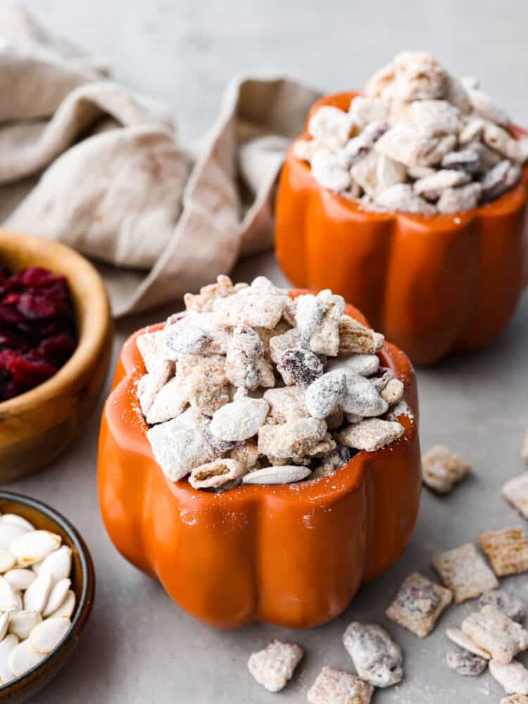 Prepare yourself for the best fall treat around- delicious pumpkin spice combined with one of the easiest treats on the planet - muddy buddies! The crunchy Chex Mix, chocolate, powdered sugar, and added cranberry and fall spices will make you want to finish the whole bowl. Pumpkin spice muddy buddies inside of a pumpkin-shaped jar.