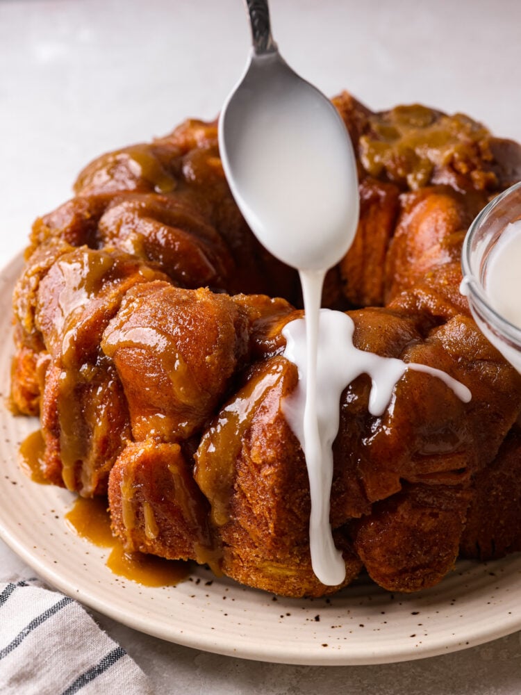 Sweet and silky Powdered Sugar Glaze is the perfect topping for your baked goods and desserts. It is so simple to make with just 3 ingredients and will be the perfect addition to your goodies! Powdered sugar glaze being drizzled on top of monkey bread.