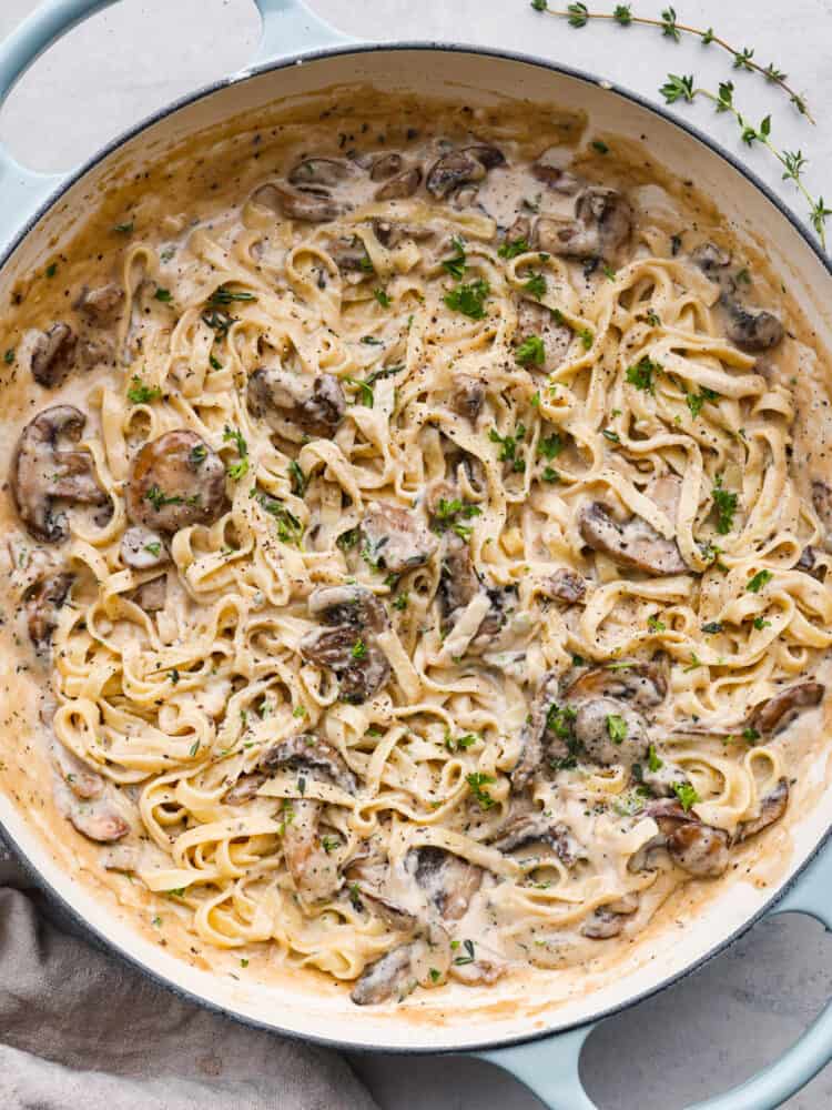This 15-minute creamy mushroom sauce is so easy to make and packed with rich, savory flavor! Youโre going to love it over pasta and meat dishes! Top-down view of mushroom pasta in a blue skillet.