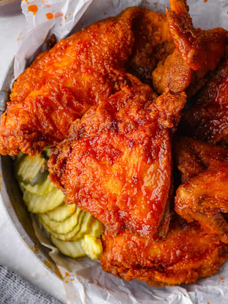 A classic Southern condiment, this Nashville hot sauce is the best for coating chicken in flavorful spice! It mixes up with just a few simple ingredients. You’re going to love having it on hand! Nashville hot chicken served with sliced pickles.