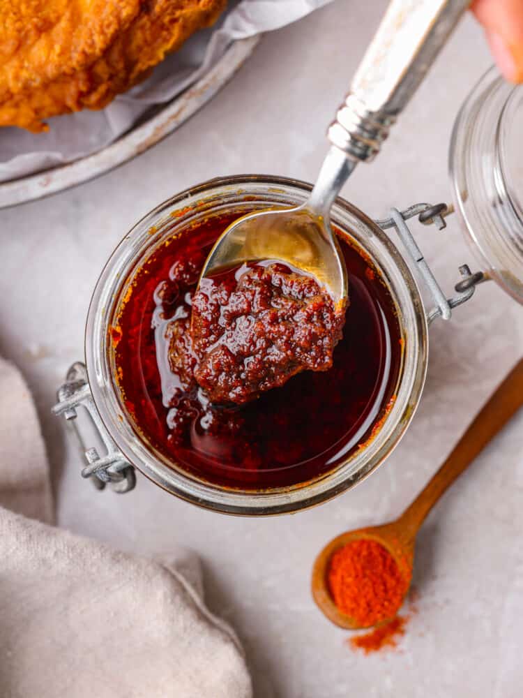 A classic Southern condiment, this Nashville hot sauce is the best for coating chicken in flavorful spice! It mixes up with just a few simple ingredients. You’re going to love having it on hand! Top-down view of Nashville hot sauce in a glass jar.