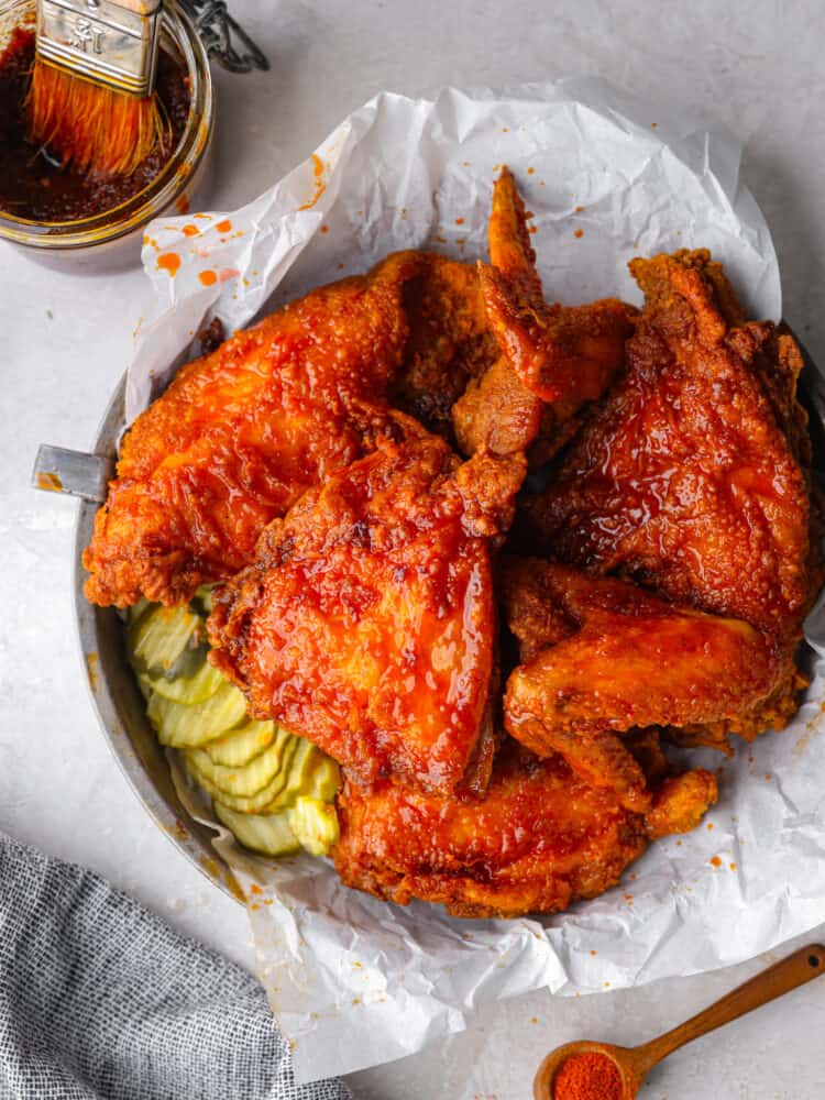 https://www.target.com/p/gourmia-5qt-12-function-guided-cook-digital-air-fryer-black/-/A-80137210#lnk=sametab Nashville hot chicken on parchment on a plate with pickles next to it.