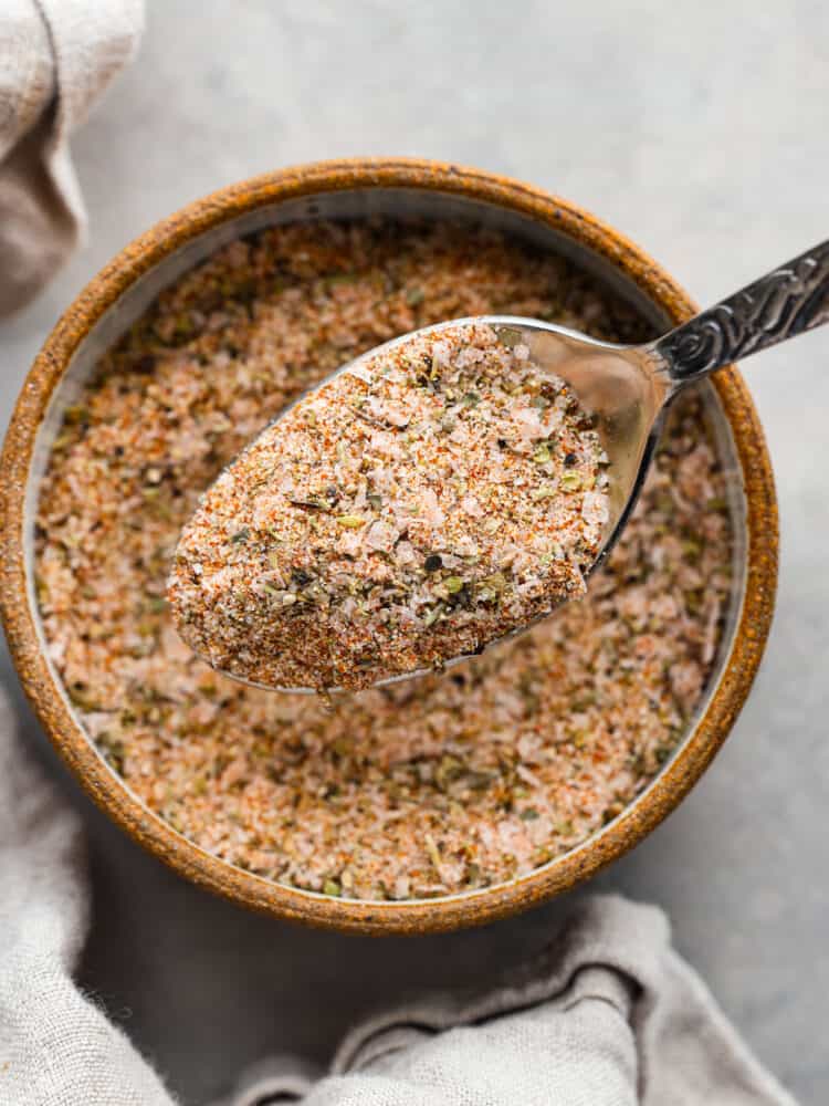 Prime Rib Rub takes 5 minutes to make and will be a staple in your spice cabinet! It is so fresh and flavorful you won't want to have your prime rib any other way. Prime rib rub in a spoon above the bowl of seasoning.