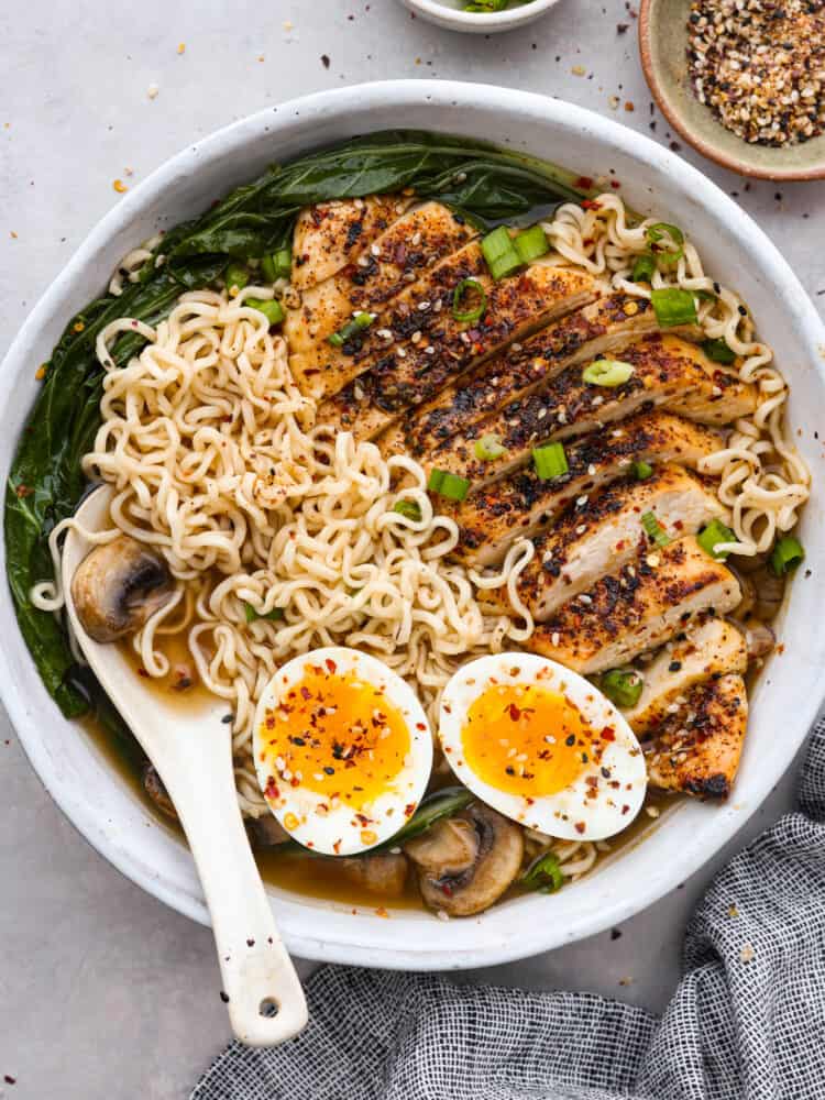 Quick and easy homemade ramen. This broth is simple to make yet bold and flavorful. Itโs perfect for pouring over some ramen noodles and loading up with your favorite toppings! This is an easy dinner that everyone will love! Top-down view of homemade ramen topped with chicken, bokchoy, and a soft boiled egg.