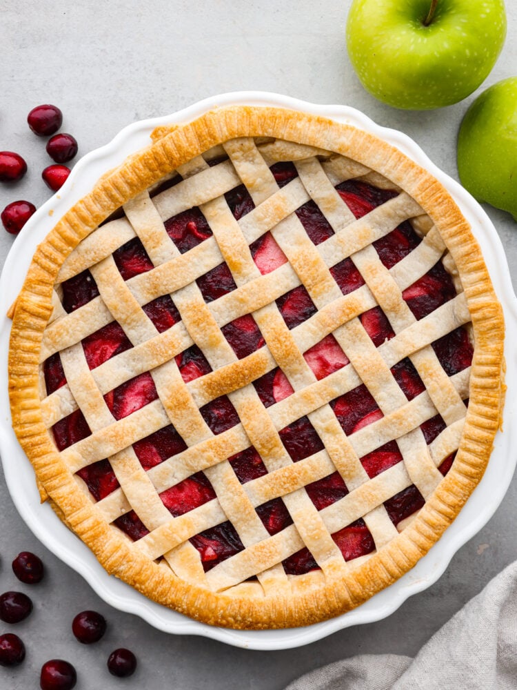 Prepare your Thanksgiving table because this cranberry apple pie is the best addition to the dinner lineup! Itโs delightfully juicy and the best combination of tart and sweet! Top-down view of a whole pie.