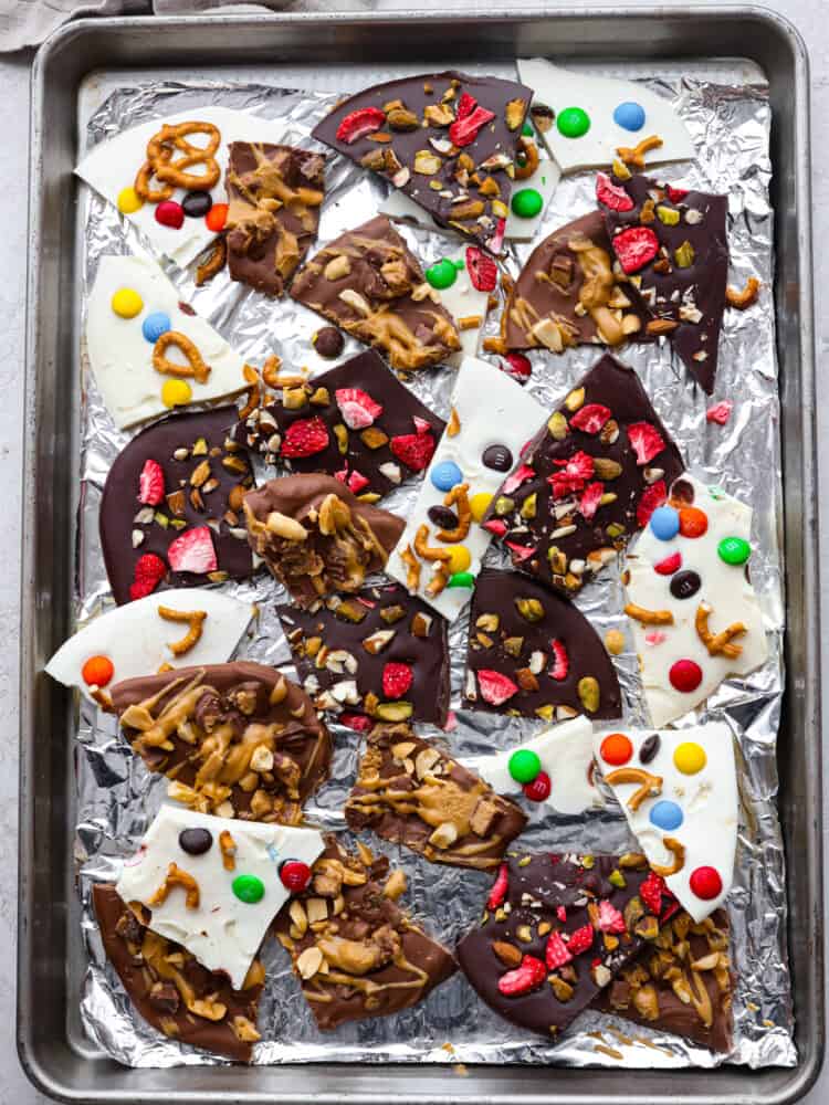 This delicious Chocolate Bark made withย Reynolds Wrapยฎ Heavy Duty Foilย will be the tastiest and simplest dessert you make all holiday season! It's quick and easy, and your entire family will go crazy over it! The topview of chocolate bark broken up on a pan lined with foil.